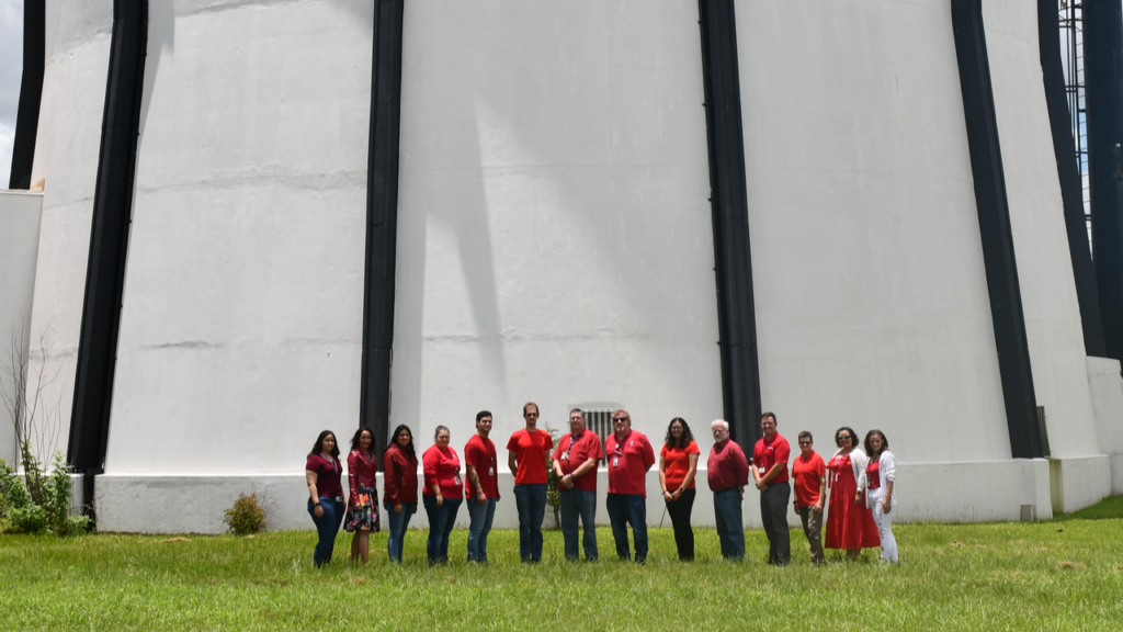 staff in red shirts in front of building